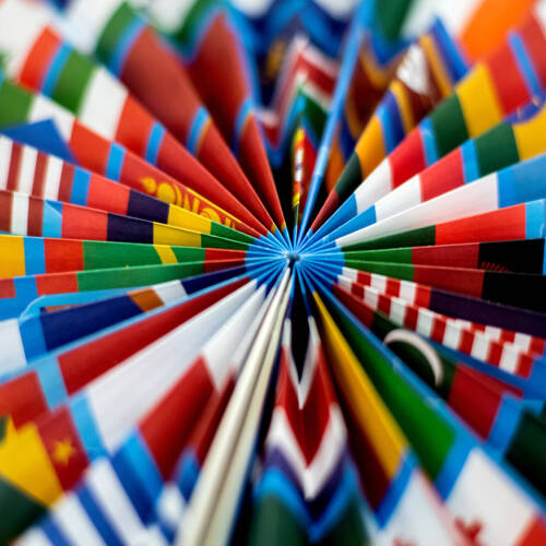 A close up on folded prints of flags into a round fan like structure.